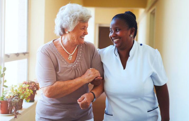 caregiver and senior woman talking while walking