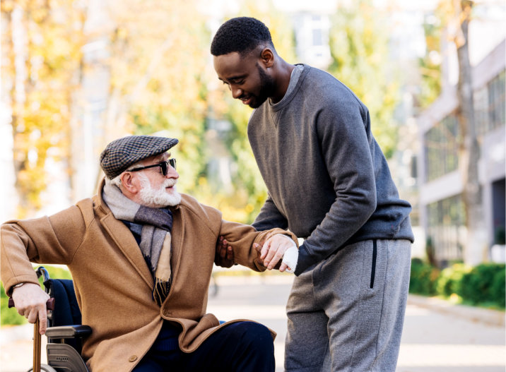 caregiver assisting senior man to stand