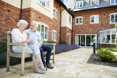 Sitting On Bench With Hot Drink In Assisted Living Facility