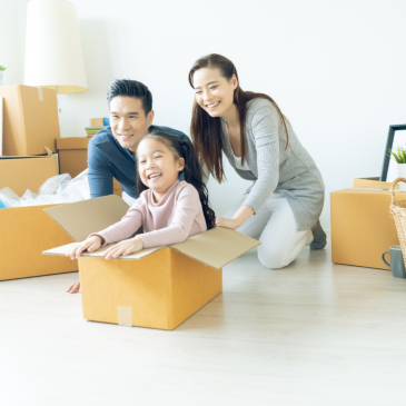 Happy young Asian family of three having fun moving with cardboard boxes in new house at moving day. Moving house day and express