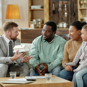 Adult counselor talking to ethnic family at home